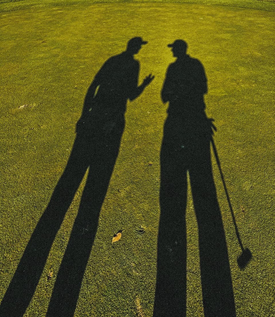 Golfers walking down a fairway